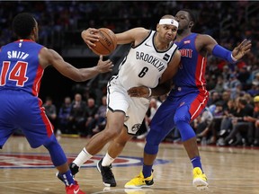 Brooklyn Nets forward Jared Dudley (6) drives between Detroit Pistons guards Ish Smith (14) and Reggie Jackson (1) during the first half of an NBA basketball game, Wednesday, Oct. 17, 2018, in Detroit.