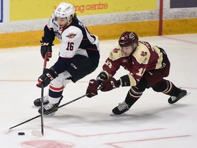 Windsor Spitfires assistant captain Chris Playfair skates the puck out of his own end with Peterborough Petes assistant Adam Timleck chasing his down in OHL action at the Memorial Centre on Saturday, Oct. 13.
