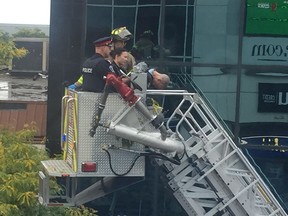 Windsor police officers get a helpful lift from a Windsor Fire and Rescue ladder crew after arresting a man found on a commercial rooftop in the 300 block of Ouellette Avenue on Oct. 2, 2018. Two large commercial A/C units from that roof were found in a neighbouring alley. Here, the handcuffed man is shown leaning forward in the bucket on his descent.