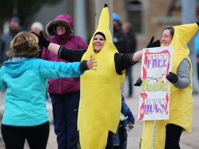 Marlo Van Mackelberg, centre, and Michelle Cross were giving out free banana hugs to racers along Goyeau Street during the 2018 Detroit Free Press/Chemical Bank Marathon on Sunday, October 21, 2018. The international race always features a run through the heart of Windsor.