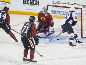 Niagara IceDogs goalie Stephen Dhillon is too late to get to the rebound as Windsor Spitfires centre Chris Playfair opens the scoring in Friday's game.