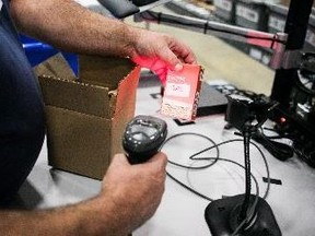 A worker scans a package of cannabis products at the Ontario Cannabis Store distribution centre in an undated handout photo. (THE CANADIAN PRESS/HO-Ontario Cannabis Store)