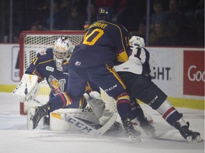 Windsor's Luke Boka misses on a scoring opportunity against Barrie's Jet Greaves as Justin Murray defends in OHL action between the Windsor Spitfires and the Barrie Colts at the WFCU Centre on Thursday.