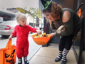 David Gibson, 3, collects some candy from Jenn Lethbridge, of S. Funtig and Associates on Pelissier St. on Wednesday, Oct. 31, 2018. Many downtown businesses handed out treats to youngsters during the Downtown Windsor BIA Spooktacular event.