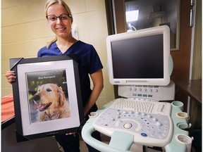 Jessica Buterbaugh, a vet tech with the Windsor-Essex County Humane Society, is shown Oct. 5, 2018, with a donated new ultrasound machine and a photo of Rex, the dog owned by the family who donated the unit.