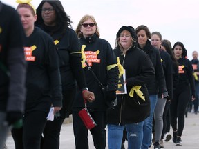 Over 100 people participated in the A21 Walk for Freedom event in downtown Windsor on Oct. 20, 2018. The purpose of the walk was to raise awareness about human trafficking. Participants are shown walking single-file and silently along the riverfront.