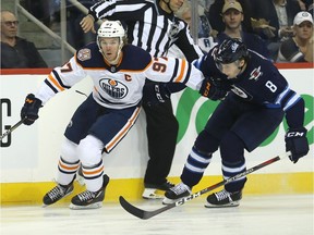 Edmonton Oilers center Connor McDavid (left) blows by Winnipeg Jets defenceman Jacob Trouba in Winnipeg on Tues., Oct. 16, 2018. Kevin King/Winnipeg Sun/Postmedia Network