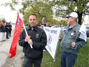 Protest organizer Mario Spagnuolo, left, joins Graham Cooper, right, and about 10 others during a roadside protest intended to raise awareness about the changes coming to labour laws under the Ontario PC government, November 1, 2018. The protest took place on the shoulder of Dougall Avenue near Ouellette Place.