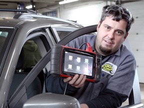 Auto repair business owner Justin Lapointe of Justin's Auto on Kildare Road works with a $5000 code scanner and data reader used to diagnose issues with vehicles.