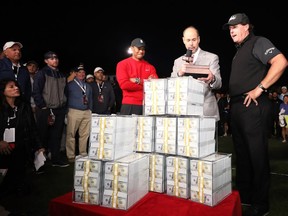 Phil Mickelson celebrates with the winnings after defeating Tiger Woods as Ernie Johnson looks on during The Match: Tiger vs Phil at Shadow Creek Golf Course on Nov. 23, 2018 in Las Vegas.