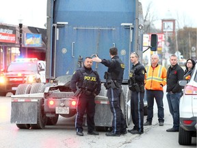 OPP investigate after a woman was dragged by a transport truck on Talbot Road at Centre Street  November 12, 2018.  Witness Peter Spanis (not shown) and others assisted the woman who was pinned underneath the Kenworth tractor.  Spanis said it was a miracle she the injured woman survived the ordeal. The woman was taken to hospital.  -