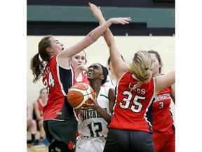 Megan Gahima, centre, of the Lajeunesse Royals, battles Julia Verscheure, left, and Emma Cadotte of Lambton Kent in SWOSSAA senior girls' A basketball final on Tuesday.