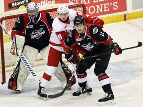 Sault Ste. Marie Greyhounds' winger Brett Jacklin (centre) battles Windsor Spitfires' defenceman Sean Allen for position in front of goalie Kari Piiroinen during Sunday's game. PETER RUICCI/Sault Star