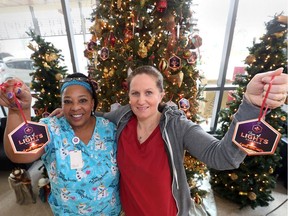 Yolanda Charles, left, and Melissa Banfill both hung oraments in memory of loved ones during the official launch of the annual Tree of Lights Campaign in the Ken Lewenza Sr. Lobby at Hotel-Dieu Grace Healthcare on Nov. 21, 2018. Employees lined up by the dozen to place their personalized ornament on a large holiday tree in the lobby. The Salvaton Army Band provided festive entertainment as Patty Handysides emceed.