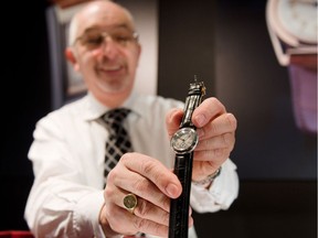 A watch dealer poses with a Rolex "Hermetique" waterproof wristwatch (c 1923) at the Mayfair Antiques and Fine Art Fair in central London on January 10, 2013. Running until January 13, the event sees independent dealers from all over the country showcasing some of their finest items under one roof. AFP PHOTO / LEON NEALLEON NEAL/AFP/Getty Images