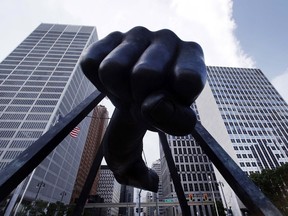 The Detroit skyline rises behind the Monument to Joe Louis, also known as "The Fist," Thursday, July 18, 2013.