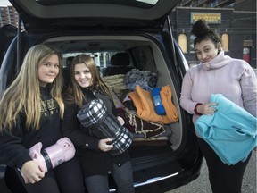 Adison Brown, 17, centre, is joined by her two helpers, Karsen Beach, 17, left, and Lindsay Funaro, 16, who delivered 230 blankets collected by staff and students at Riverside Secondary School and given to Ideal Way for their Caring Covers program outside the Downtown Mission, Saturday, November 3, 2018.  The blankets will be given out locally to shelters and organizations.