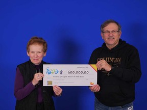 Victoria and Eugene Boivin of Belle River hold up the $500,000 prize cheque they won from the Lotto MAX draw of Oct. 12, 2018.