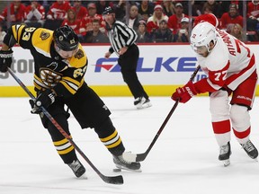 Detroit Red Wings center Andreas Athanasiou (72) steals the puck from Boston Bruins left wing Brad Marchand (63) in overtime during an NHL hockey game Wednesday, Nov. 21, 2018, in Detroit. Detroit won 3-2.