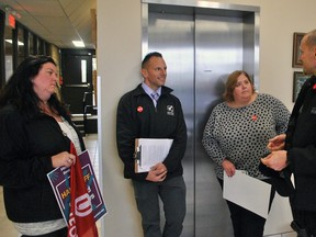 Sgt. Paul Pomajba with the Chatham-Kent Police Service, right, speaks with Unifor Local 127 president Nicole Grainger, left, Mario Spagnuolo, recording secretary with the Windsor & District Labour Council, and Heather Latam outside Chatham-Kent-Leamington MPP Rick Nicholls office in Chatham Nov. 2, 2018. Due to vandalism and a break in at another Progressive Conversative MPP's office, members have been asked to call the police if there are any protests related to Bill 47, which repeals some labour laws introduced by the previous Liberal government. (Tom Morrison/Postmedia News)