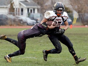 L'Essor Aigles' James Morales (85) is tackled by Wallaceburg Tartans' Austin Salisbury in the third quarter of the SWOSSAA AA senior football final at Wallaceburg District Secondary School in Wallaceburg on Saturday.