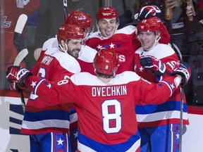 Washington Capitals left wing Andre Burakovsky, centre, from Austria, celebrates his goal as left wing Alex Ovechkin joins in during the third period of an NHL hockey game against the New Jersey Devils, Nov. 30, 2018, in Washington. The Capitals won 6-3.