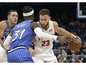 Detroit Pistons' Blake Griffin (23) looks for a way around Orlando Magic's Aaron Gordon, left, and Terrence Ross (31) during the first half of an NBA basketball game, Wednesday, Nov. 7, 2018, in Orlando, Fla.