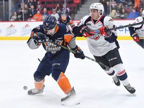 Windsor Spitfires defenceman Nathan Staios (right) battles Flint's Jacob Winterton for a loose puck.