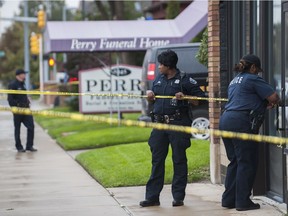 Detroit Police officers use crime scene tape to cordon off the area while they execute a search warrant at the Perry Funeral Home in Detroit on Friday, Oct. 19, 2018. Police removed the remains of 63 fetuses from the funeral home and regulators shuttered the business amid a widening investigation of alleged improprieties at local funeral homes.