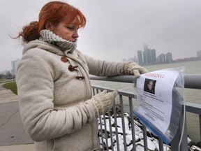 Terri Banfill affixes a missing notice she made for her father Murray Banfill along the downtown Windsor riverfront on Nov. 16, 2018. Her father, who goes by the name of Gus, suffers from dementia and mental illness and has been missing since Monday.