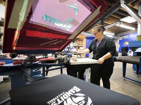 Sherry Renaud of Hogan's Printing prepares to print T-shirts at the new temporary location of the business at 1636 Tecumseh Rd. East on Nov. 8, 2018.
