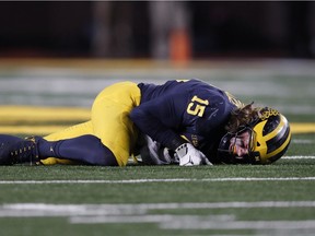 Michigan defensive lineman Chase Winovich winces on the ground before leaving the game with an injury in the second half of an NCAA college football game in Ann Arbor, Mich. on Nov. 17, 2018.