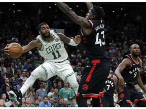 Boston Celtics guard Kyrie Irving (11) passes the ball against the defense of Toronto Raptors forwards Pascal Siakam (43) and Serge Ibaka (9) in the fourth quarter of an NBA basketball game, Friday, Nov. 16, 2018, in Boston. Irving scored 43 points to lead the Celtics to a 123-116 victory in overtime.