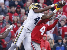 Michigan receiver Nico Collins, left, catches a pass in front of Ohio State defensive back Jordan Fuller during the second half of an NCAA college football game on Nov. 24, 2018, in Columbus, Ohio. Ohio State beat Michigan 62-39.