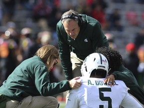 Michigan State head coach Mark Dantonio, top, checks on injured player Andrew Dowell (5) in the first half of an NCAA college football game against Maryland, Saturday, Nov. 3, 2018, in College Park, Md. Michigan State defeated Maryland, 24-3.