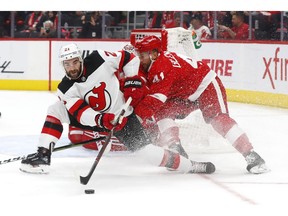 Detroit Red Wings center Luke Glendening (41) defends New Jersey Devils right wing Kyle Palmieri (21) during the first period of an NHL hockey game Thursday, Nov. 1, 2018, in Detroit.