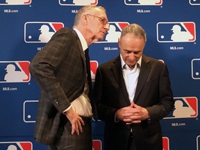 DAZN chairman John Skipper, left, speaks to Major League Baseball commissioner Rob Manfred at the baseball owners meeting in Atlanta on Nov. 15, 2018.