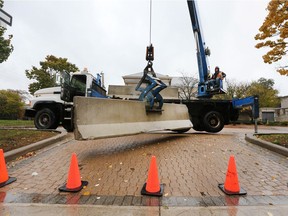 A worker installs a concrete barrier at the entrance to the MacKenzie Hall parking lot in Windsor, ON. on Thursday, November 1, 2018.