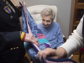 Wartime veteran Margaret Dunbar, 97, receives a Quilt of Valour, one of 47 given locally, at her son's home on Nov. 17, 2018.
