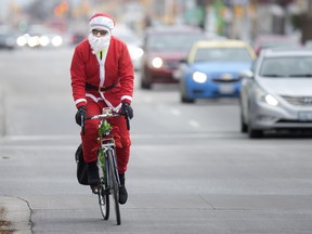 Spirit of Christmas. Ron Thibert, one of a dozen cyclists dressed as Santa, looks to give out gift cards to those in need on Wyandotte Street West in downtown Windsor on Nov. 17, 2018.