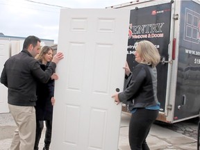 Sentry Windows & Doors owners Ken and Tamar Sherman give Fiona Coughlin (right), executive director at Habitat for Humanity Windsor-Essex, a helping hand with some windows and doors they donated.