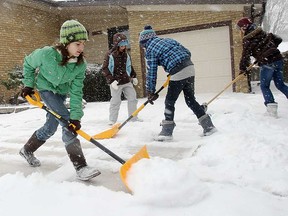Volunteer snow shovellers clear a driveway and sidewalk in Windsor in February 2010.