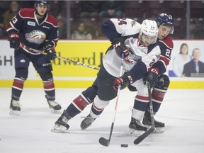 Windsor's Mathew MacDougall, left, battles Saginaw's Danny Katic in OHL action between the Windsor Spitfires and the Saginaw Spirit.