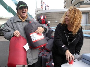 John Lewis, left, appreciates receiving  sleeping bags, a blanket and coffee  from volunteer Kim Zdunich.  A group of volunteers gave away 140 sleeping bags to area homeless at Charles Clark Square Sunday. Lewis said he currently lives at the Downtown Mission but will be moving in with a friend and the sleeping bags will come in handy.