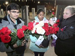 University of Windsor's Rupesh Vagheshwari, left, Deepthi B. Jampana and Eva Kratochvil, right, prepare roses for the National Day of Remembrance and Action on Violence Against Women event held at Memorial of Hope on the university's main campus Thursday evening.