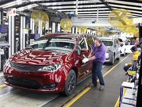 Inspector Frank Calzavara, front, with a Chrysler Pacifica Hybrid in velvet red in the Final Car area of FCA Canada Windsor Assembly Plant on Dec. 7, 2018.