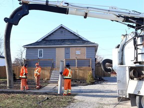 Crews with Enwin Utilities and a hydro excavation company, shown Dec. 8, 2018, work to locate the water shutoff at a home in the 1000 block of Westminster Blvd. following an overnight house fire which caused extensive damage to an east Windsor home. The home had several cars with For Sale signs parked around the driveway.