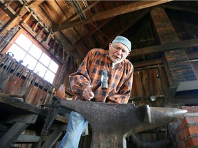 John R. Park Homestead blacksmith Julius Langpeter hammers hot iron into the shape of a two-pronged fork during Sunday's Christmas in the County event.