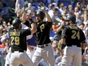 Pittsburgh Pirates' Jordy Mercer, center, celebrates with Francisco Cervelli, left, and Pedro Alvarez after hitting a three-run home run during the fifth inning of a baseball game against the Chicago Cubs on Sept. 26, 2015, in Chicago.