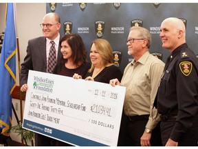Mayor Drew Dilkens, left, Lisa Kolody, Shelley Atkinson, Kevin Sivell and Windsor Police Chief Al Frederick pose after a $21,034 donation to the John Atkinson Memorial Scholarship Fund during the Dec. 12, 2018, Windsor Police Service board meeting.
